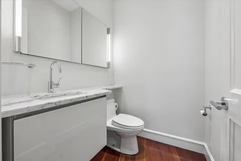 a bathroom with a granite countertop toilet sink and mirror