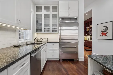 a kitchen with granite countertop a sink and a wooden floor