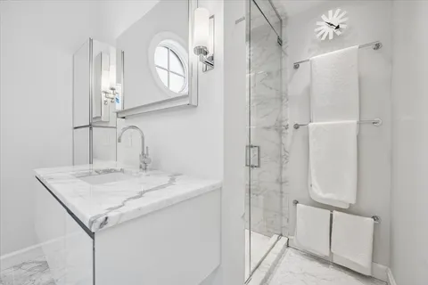 a bathroom with a granite countertop sink a mirror and shower