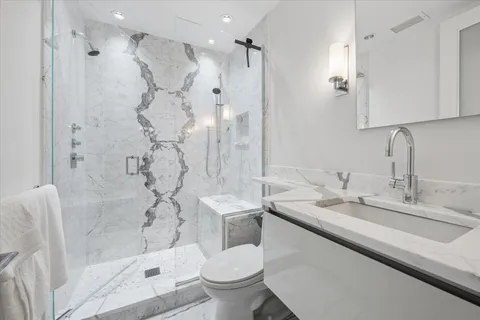 a bathroom with a granite countertop sink toilet and shower