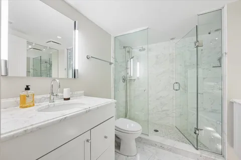 a bathroom with a sink a toilet and shower