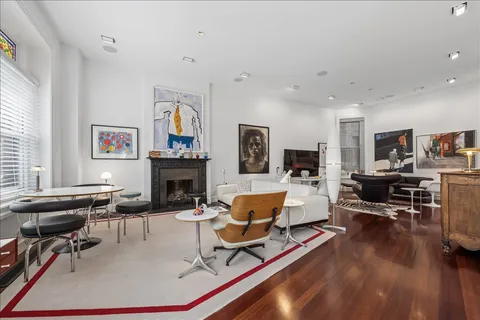 a living room with furniture a fireplace and a large window
