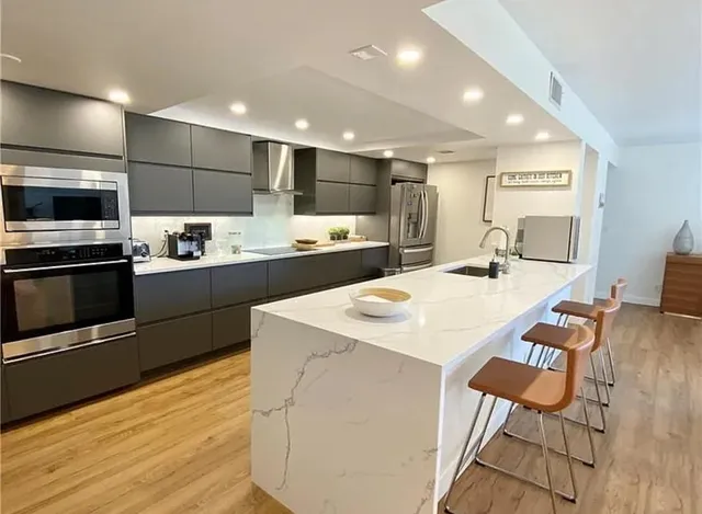 a kitchen with stainless steel appliances kitchen island granite countertop a sink and cabinets
