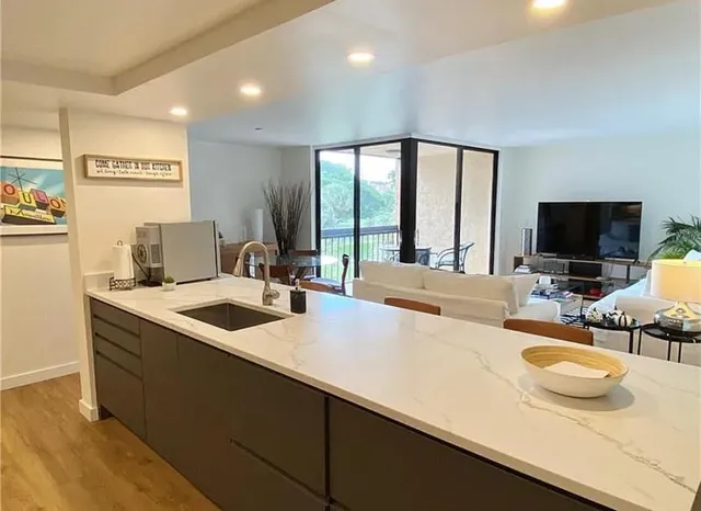 a view of a kitchen with kitchen island a sink and a large window
