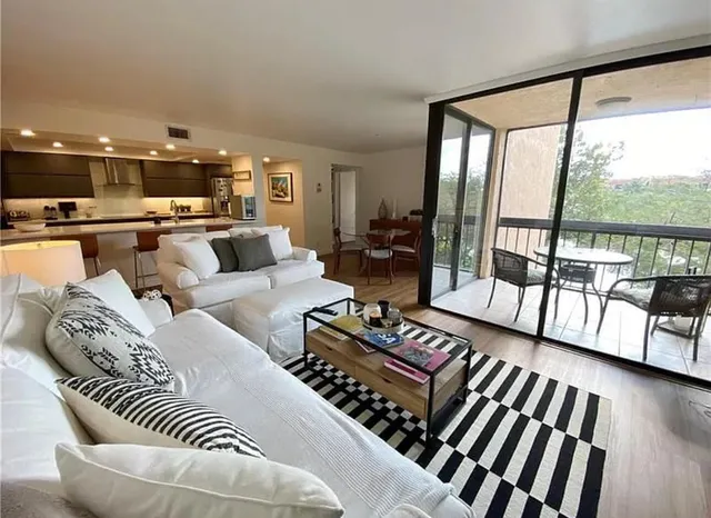 a living room with furniture and a floor to ceiling window
