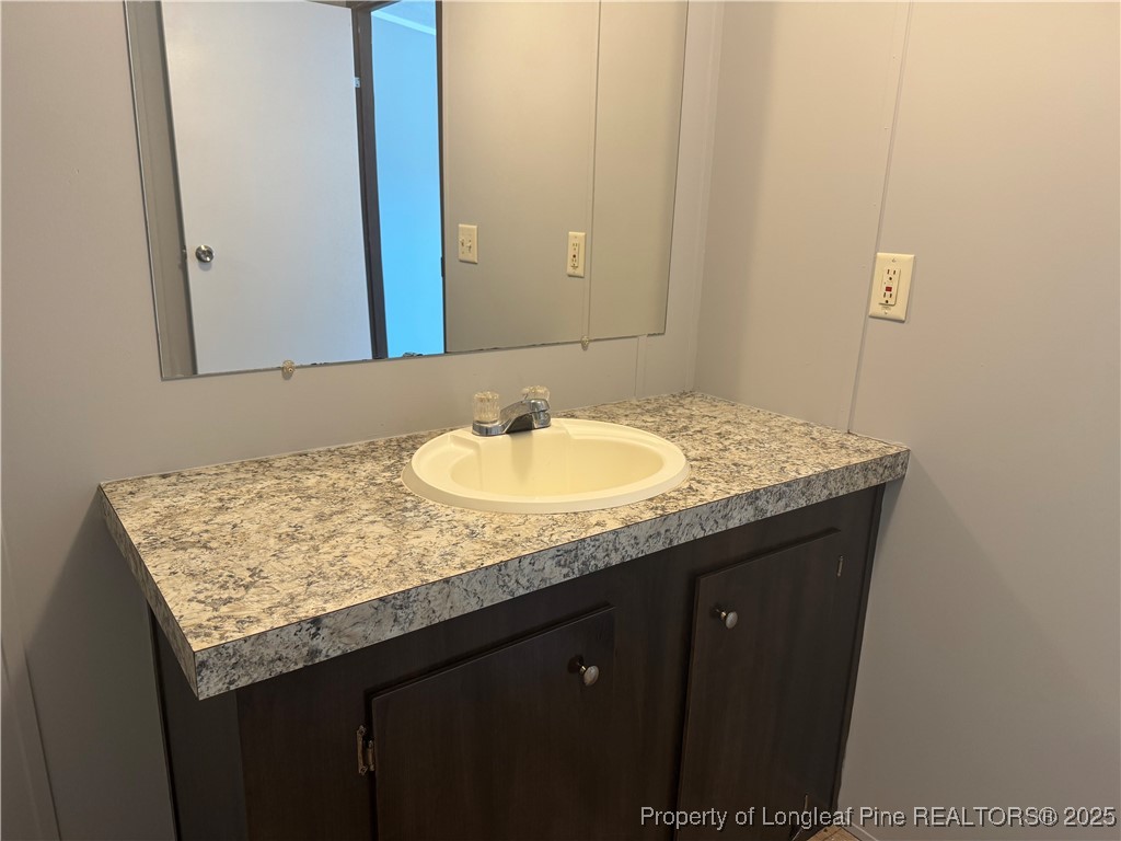 2273 Bee Gee Road Lumberton, NC 28358 - Photo 18 of 35 a bathroom with a granite countertop sink and a mirror