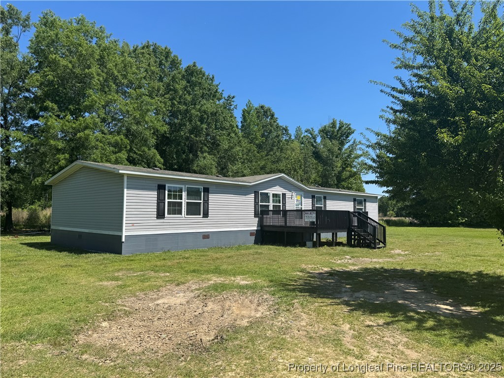 2273 Bee Gee Road Lumberton, NC 28358 - Photo 9 of 35 a house that is sitting in the grass with large trees and plants