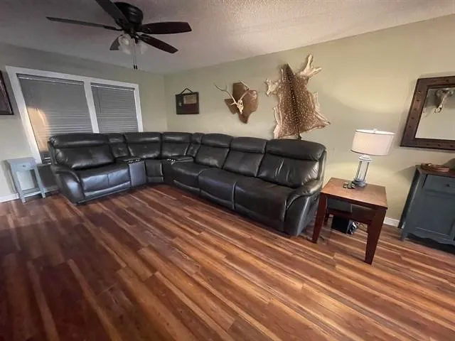 a living room with furniture and a wooden floor