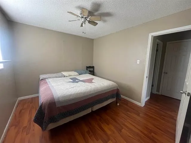 a bedroom with a bed and a flat tv screen on the dresser