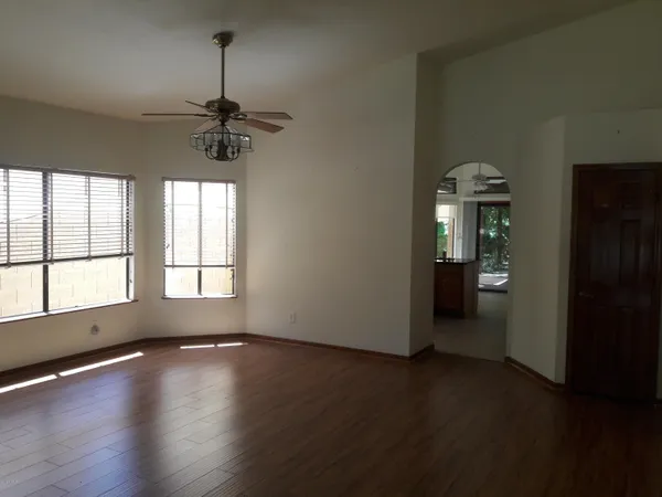 a view of an empty room with window and wooden floor