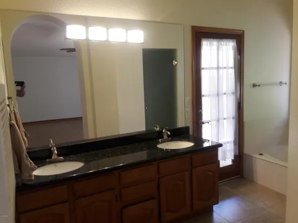 a bathroom with a double vanity sink and a mirror