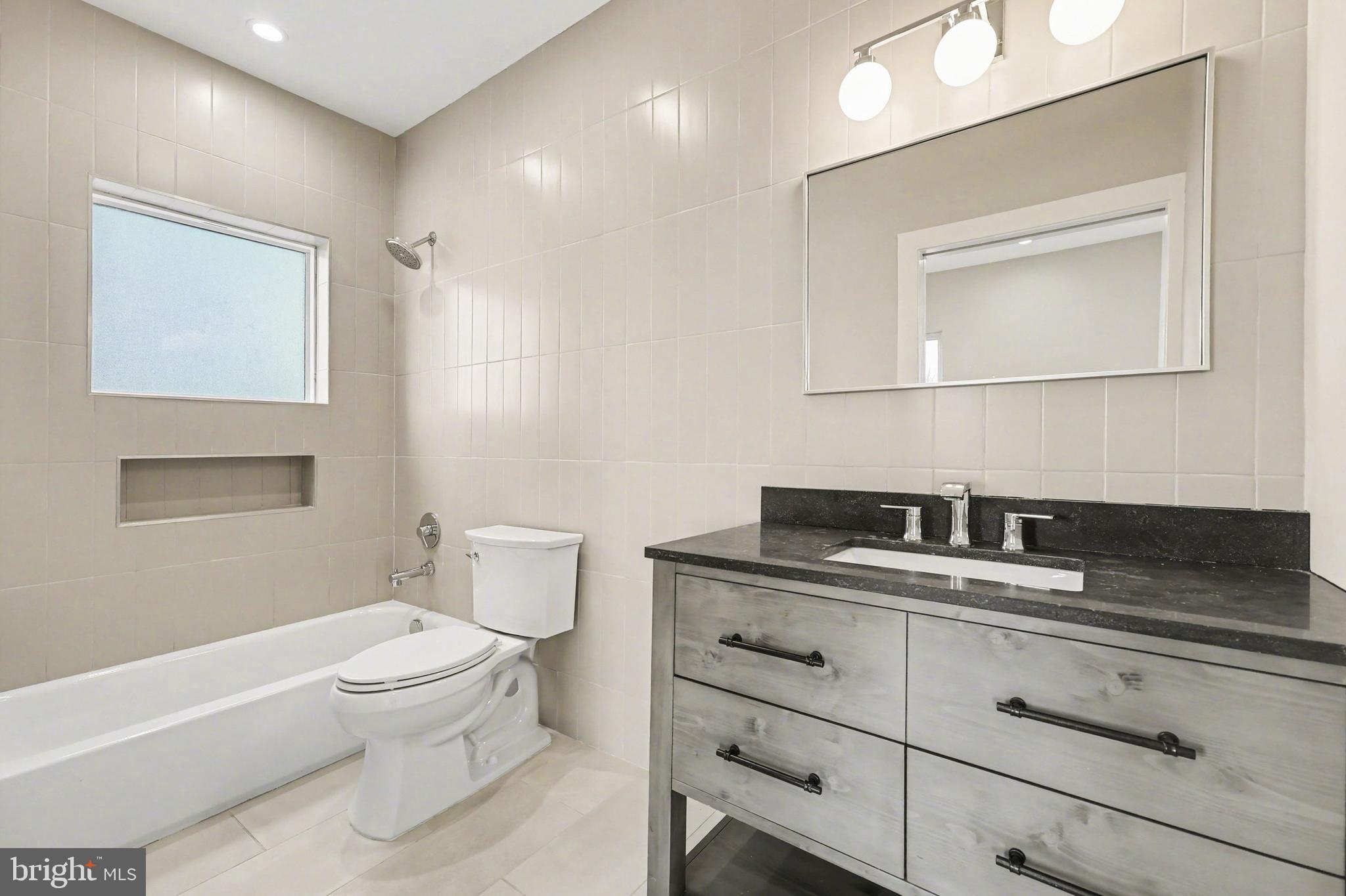 842 Madison Street Northwest, Unit 2 Washington, DC 20011 - Photo 14 of 27 a bathroom with a granite countertop sink mirror vanity and toilet