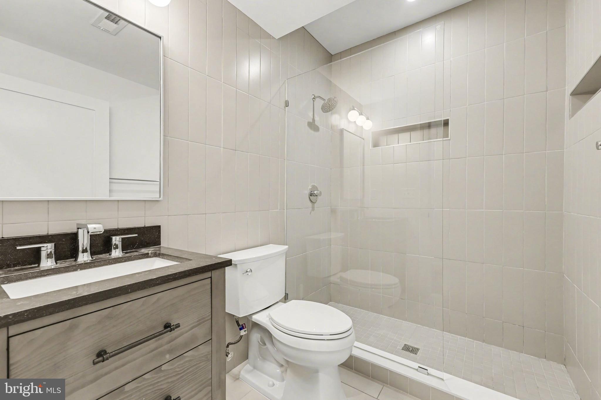 842 Madison Street Northwest, Unit 2 Washington, DC 20011 - Photo 18 of 27 a bathroom with a sink a toilet and shower