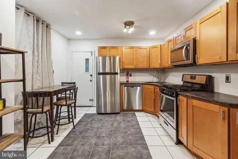a kitchen with stainless steel appliances granite countertop a refrigerator stove microwave and sink