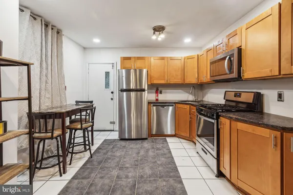 a kitchen with stainless steel appliances granite countertop a refrigerator stove microwave and sink