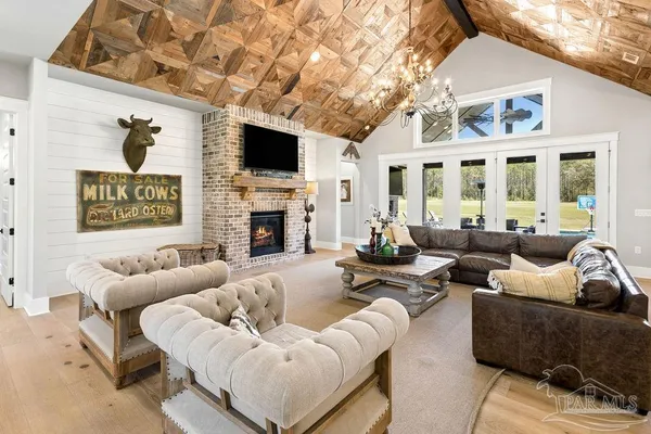 a kitchen with stainless steel appliances a stove a sink dishwasher a dining table and chairs with wooden floor