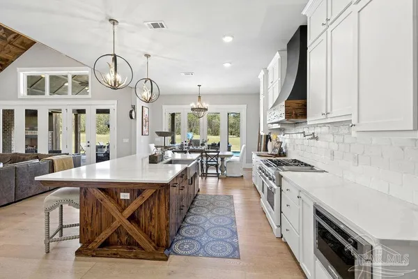 a view of a dining room with furniture a chandelier and wooden floor
