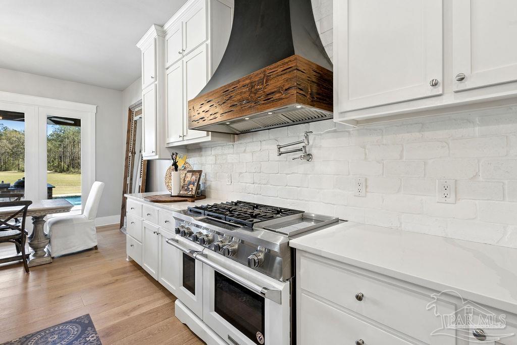 7520 Hidden Forest Trail Pace, FL 32571 - Photo 17 of 65 a kitchen with stainless steel appliances granite countertop a stove and a white cabinets