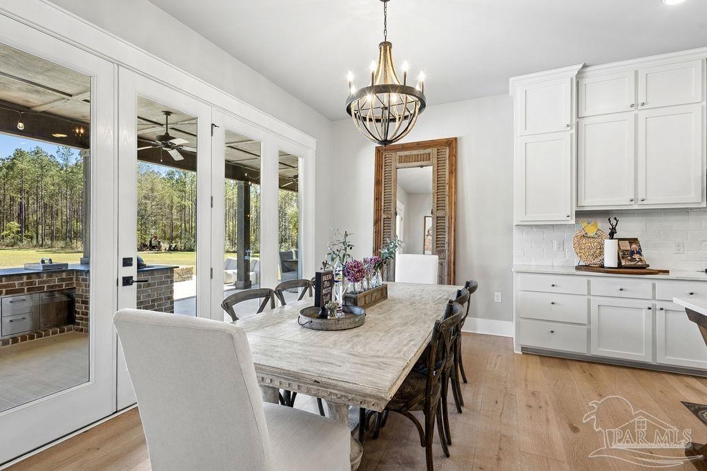 7520 Hidden Forest Trail Pace, FL 32571 - Photo 20 of 65 a view of a dining room with furniture a chandelier and wooden floor