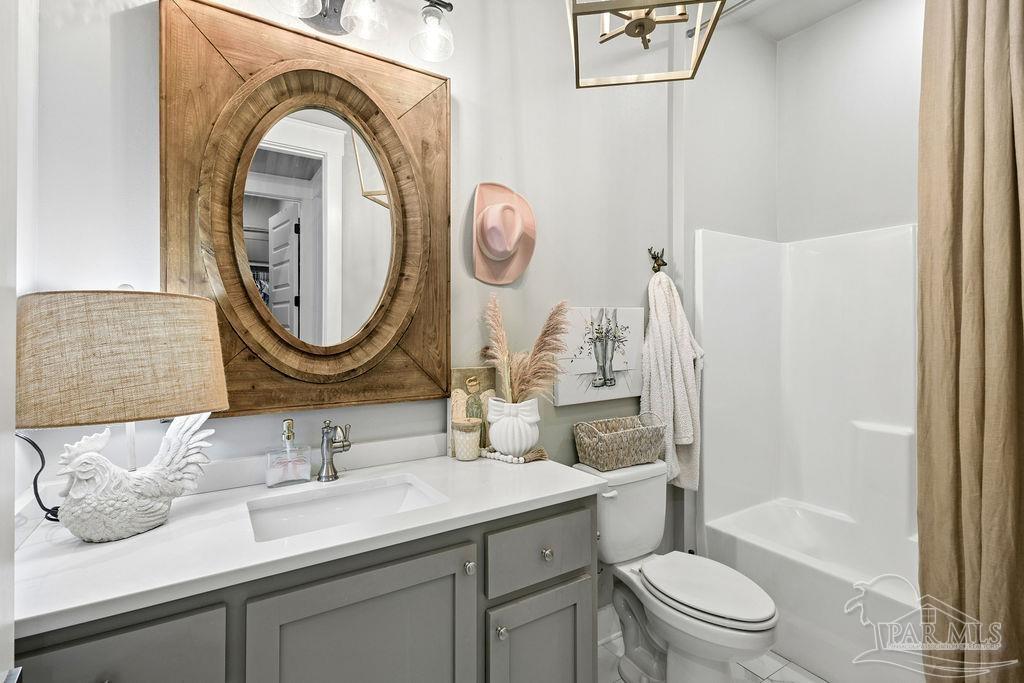 7520 Hidden Forest Trail Pace, FL 32571 - Photo 31 of 65 a bathroom with a granite countertop toilet a sink and a mirror