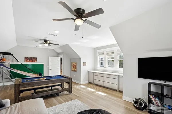a living room with furniture a flat screen tv and a floor to ceiling window