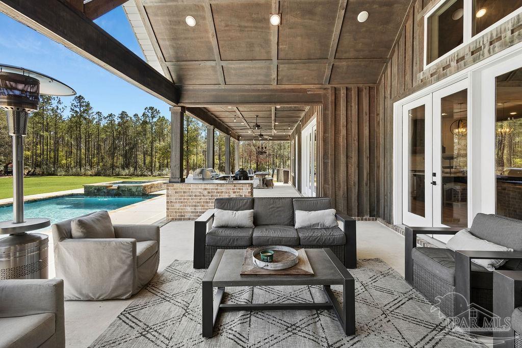 7520 Hidden Forest Trail Pace, FL 32571 - Photo 51 of 65 a outdoor space with patio the couches and a dining table with the view of garden