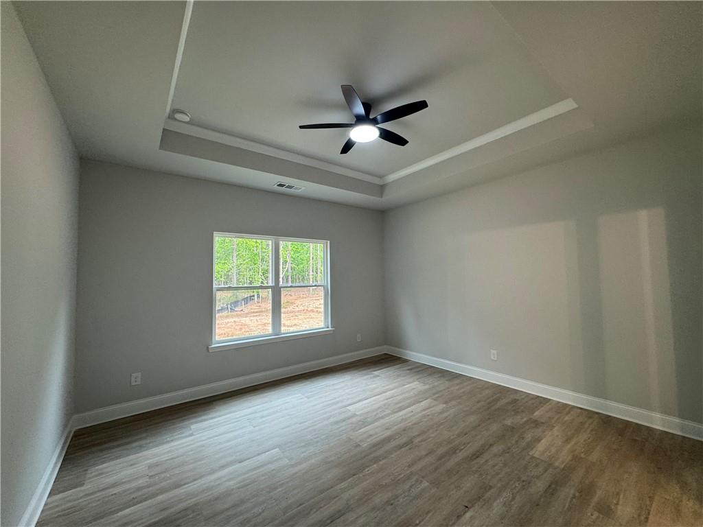 2057 North Hicks Road Toccoa, GA 30577 - Photo 13 of 23 an empty room with wooden floor ceiling fan and windows