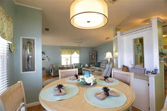 a living room with furniture a large window and kitchen view