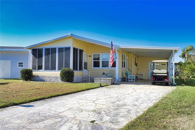 a front view of a house with a yard and potted plants