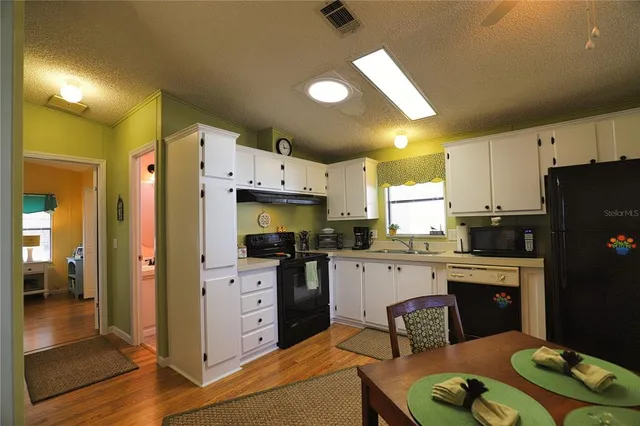 a dining room with furniture a chandelier and wooden floor