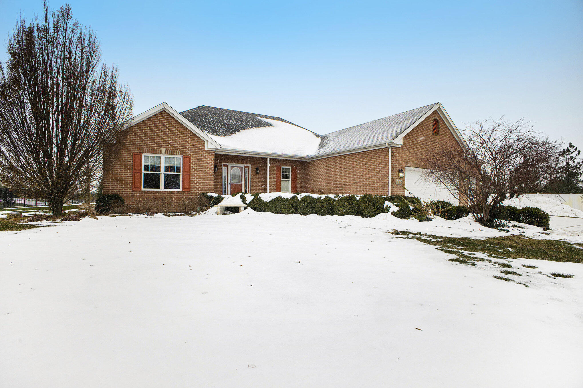 a front view of a house with a yard covered in snow