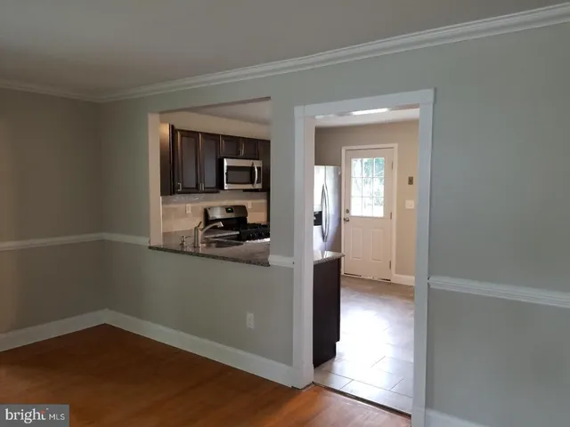 a kitchen with a refrigerator and a stove top oven