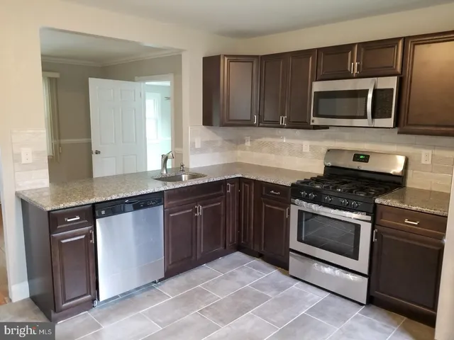 a kitchen with stainless steel appliances granite countertop a stove microwave and sink