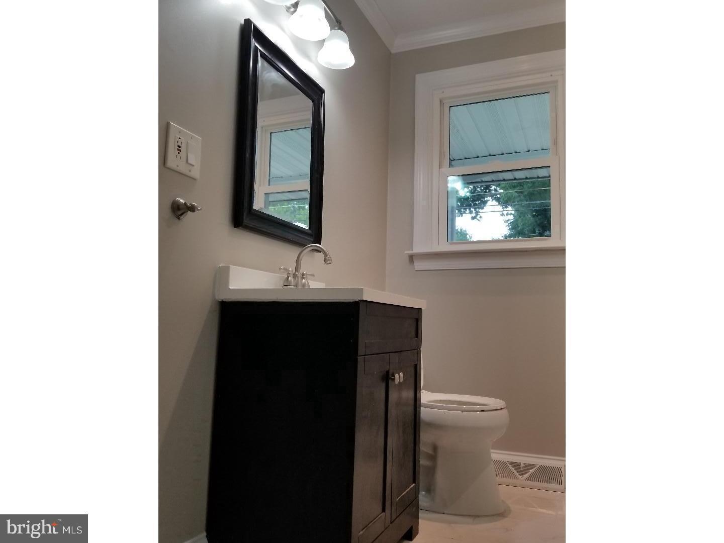 229 Deptford Road Glassboro, NJ 08028 - Photo 7 of 7 a bathroom with a toilet a sink and mirror