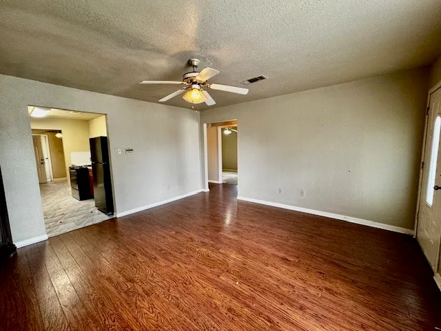 a view of a livingroom with wooden floor and a ceiling fan