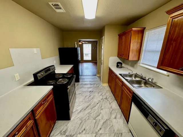 a kitchen with sink stove and refrigerator