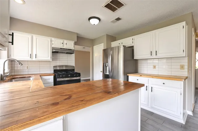 a kitchen with stainless steel appliances granite countertop a refrigerator and a stove top oven