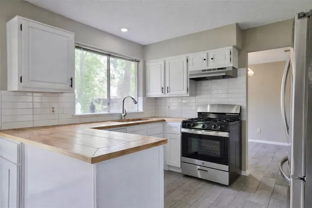 a kitchen with white cabinets and a stove top oven