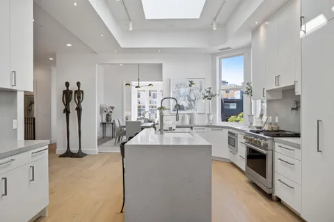 a kitchen with stainless steel appliances kitchen island granite countertop a refrigerator and a stove top oven