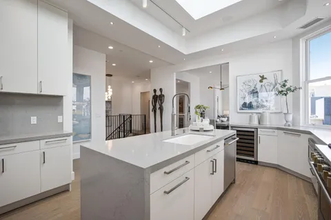 a kitchen with white cabinets appliances and center island