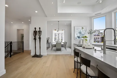 a living room with furniture a large window and wooden floor
