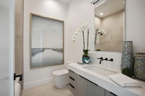 a bathroom with a granite countertop sink a toilet and shower
