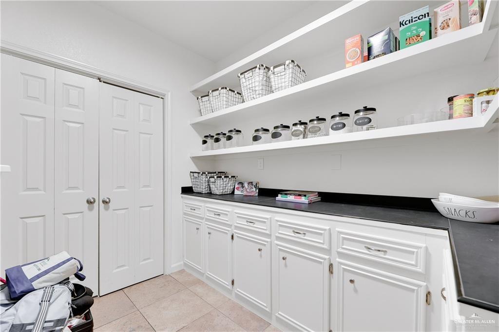 2036 South 5th Street, Unit 8 McAllen, TX 78503 - Photo 11 of 27 a kitchen with white cabinets and shelf with wooden floor