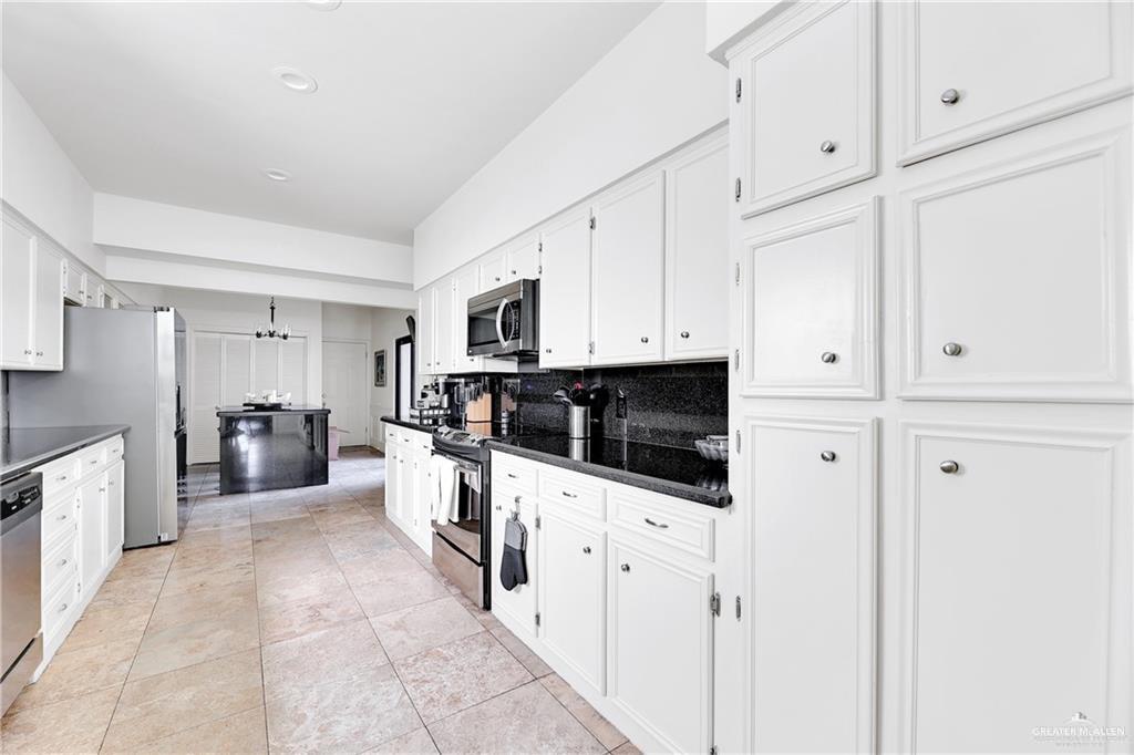 2036 South 5th Street, Unit 8 McAllen, TX 78503 - Photo 8 of 27 a kitchen with granite countertop white cabinets a sink a stove a oven with dining table and chairs