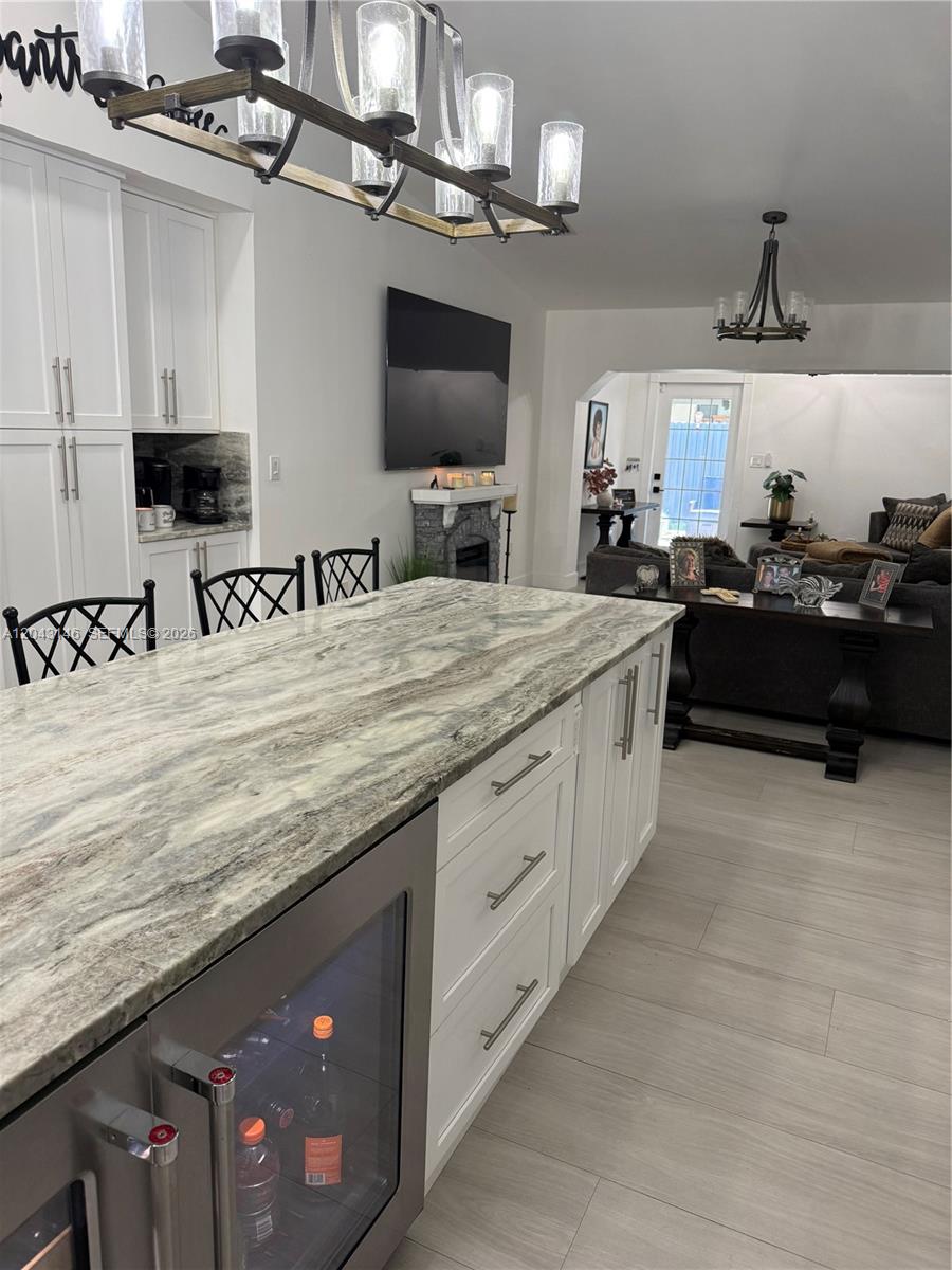 4947 Southwest 143rd Avenue Miami, FL 33175 - Photo 9 of 19 The 15 feet island with under the counter refrigerator and wine cooler. Cabinets are all pull-out drawers. Pantry and coffee station in background.