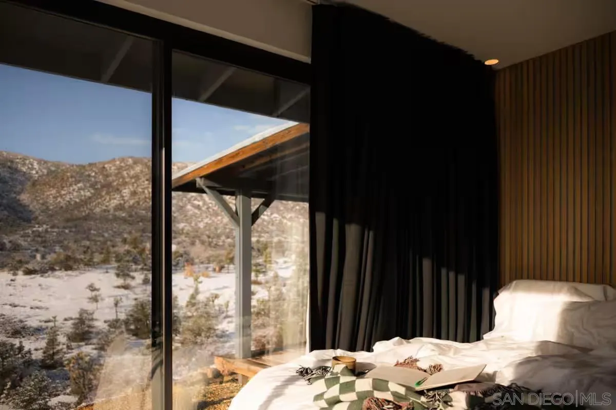 48311 Burns Canyon Road Pioneertown, CA 92268 - Photo 21 of 52 a bed sitting in a bedroom next to a window