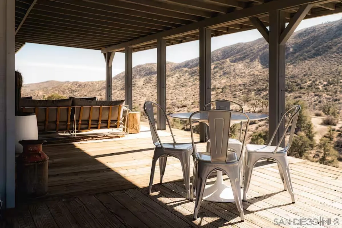48311 Burns Canyon Road Pioneertown, CA 92268 - Photo 7 of 52 a view of a patio with a table chairs and wooden floor
