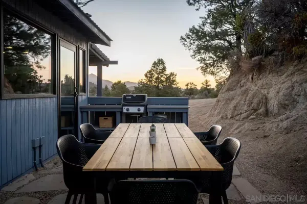 a roof deck with table and chairs and wooden floor