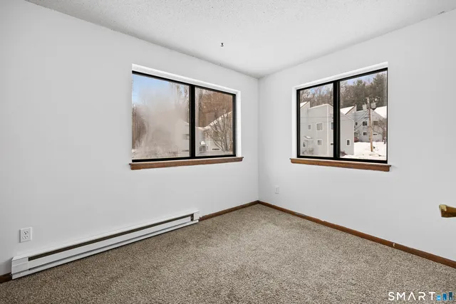 an empty room with windows and closet