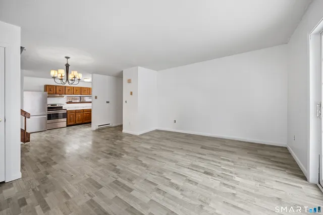 a view of empty room with kitchen and window